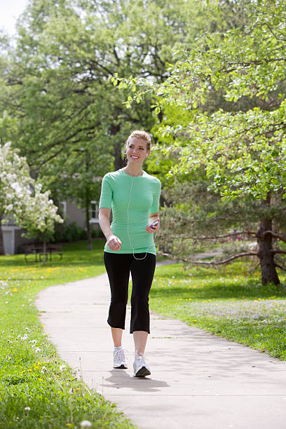 Happy woman walking with MP3 player stock photo