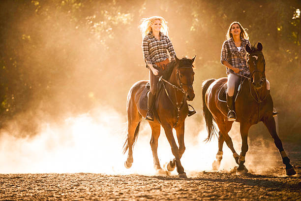 happy women riding horses at sunset. - smiling earth horse bildbanksfoton och bilder
