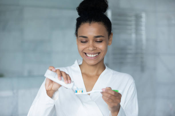 gelukkige jonge afrikaanse amerikaanse vrouw die munttandpasta knijpt - bad breath stockfoto's en -beelden