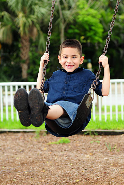 Happy young child swinging stock photo