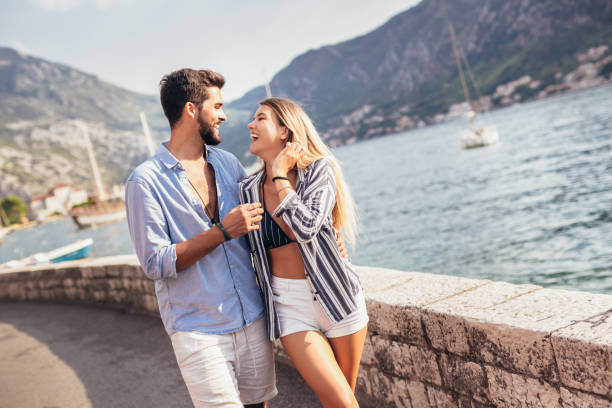 Happy young couple laughing and hugging on the beach stock photo