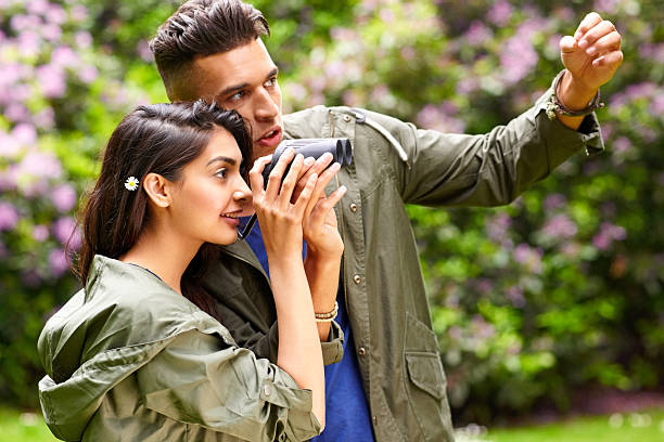Happy young couple looking for beauties of nature Portrait of happy young couple looking for beauties of nature through binoculars asian beauties stock pictures, royalty-free photos & images