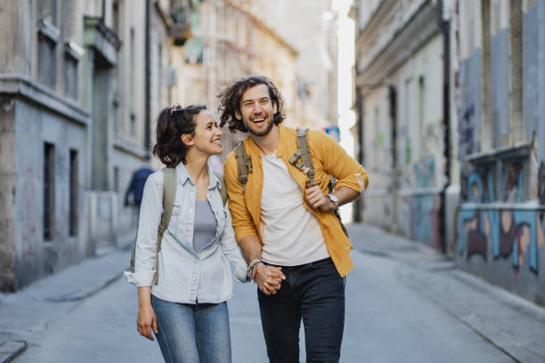 Happy young couple traveling together Young couple walking together on the street and holding hands city break stock pictures, royalty-free photos & images