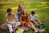 istock Happy Young Family is Having a Picnic in a Park. 1331687519