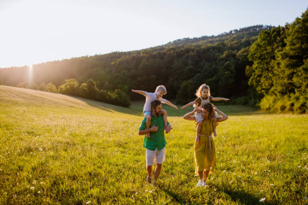 Happy young family spending time together outside in green nature. stock photo