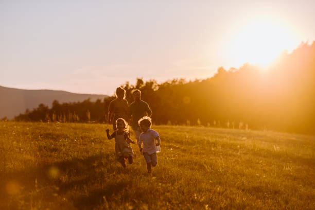 Happy young family spending time together outside in nature during sunset. stock photo