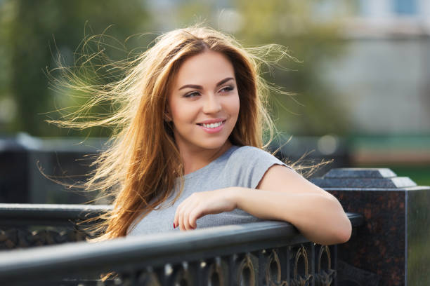 Happy young fashion woman with long straight hair in gray t-shirt stock photo