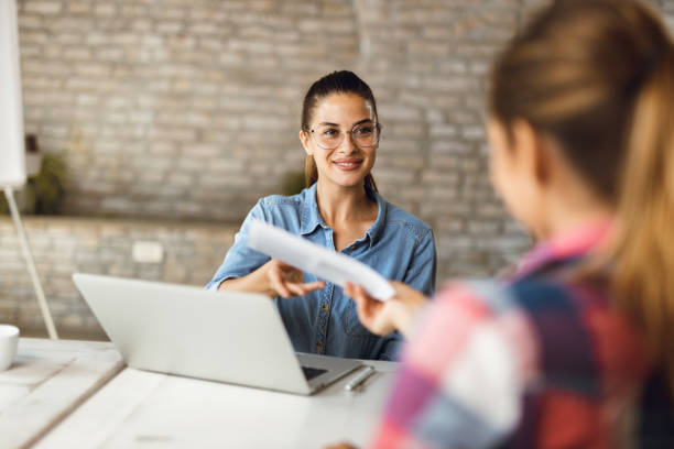 Happy young  financial advisor talking to a customer in the office stock photo
