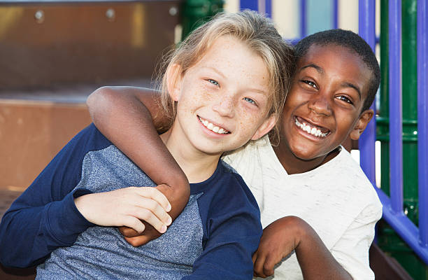 Happy young friends sitting together stock photo