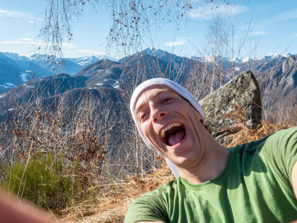 Happy young man takes selfie outdoors on a sunny day stock photo