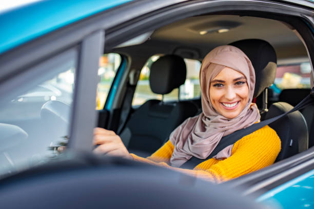 gelukkige jonge moslim vrouw met mooie glimlach rijden auto. - arabic student stockfoto's en -beelden