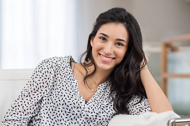 Happy young woman Closeup of a smiling young woman looking at camera. Portrait of happy brunette girl smiling at home. Relaxed woman at home smiling. beautiful latina woman stock pictures, royalty-free photos & images