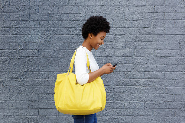 happy young woman reading text message on mobile phone - kvinna på väg bildbanksfoton och bilder