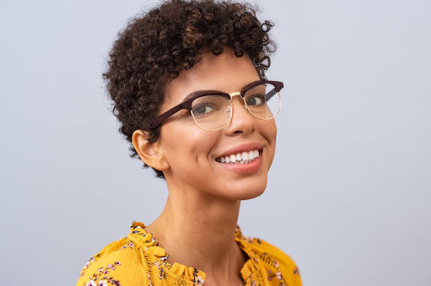 Happy young woman with eyeglasses Beautiful young brazilian woman with spectacles looking at camera. Cheerful toothy smile girl with eyewear against grey background looking at camera. Portrait of casual african woman with new eyeglasses smiling. pardo brazilian stock pictures, royalty-free photos & images