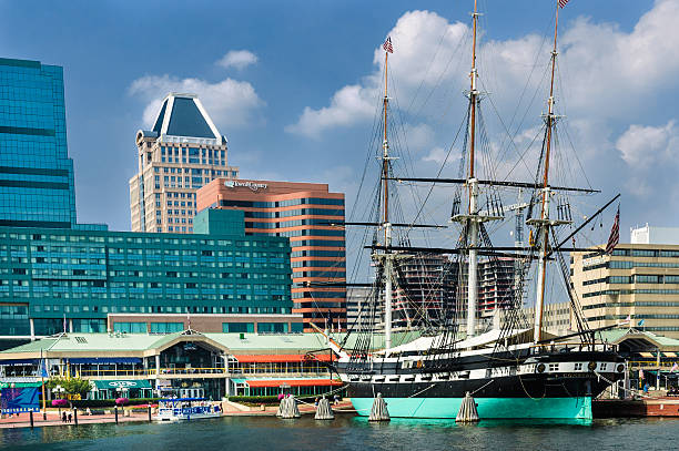 Harborplace Baltimore Baltimore, Maryland, USA - July 21, 2006: A water taxi stops next to the U.S.S Constellation to pick up passengers to various points in Baltimore Harbor inner harbor baltimore stock pictures, royalty-free photos & images
