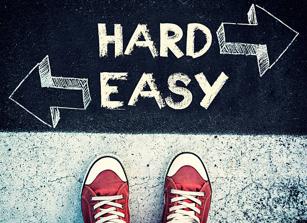 Hard and easy dilemma Student standing above the hard and easy sign,dilemma concept toughness stock pictures, royalty-free photos & images
