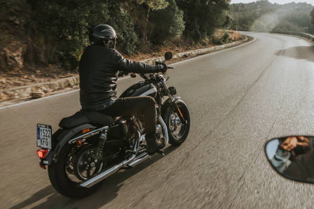 Harley Davidson going along a narrow mountain road during meeting in Malaga, Spain. stock photo