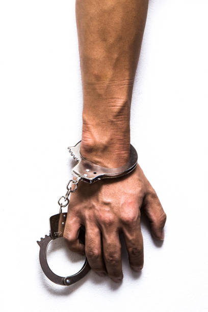 harsh light image of hand with many handcuffs - prision imagens e fotografias de stock