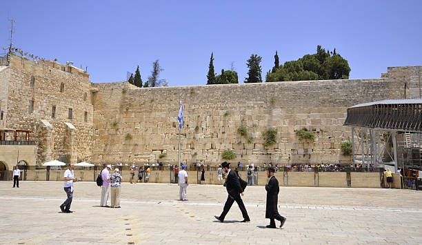 Hasidic Jews walk along the Western Wall in Jerusalem, Israel stock photo