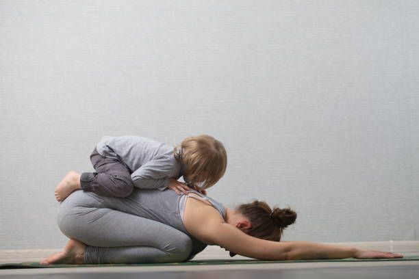 Hatha yoga fitness mother with baby stock photo