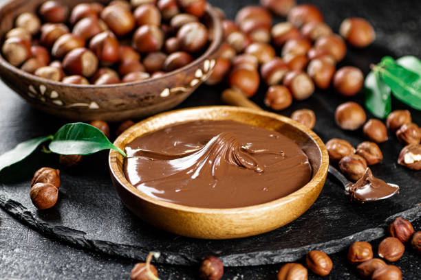 Hazelnut butter on a stone board on a plate and in a spoon. stock photo