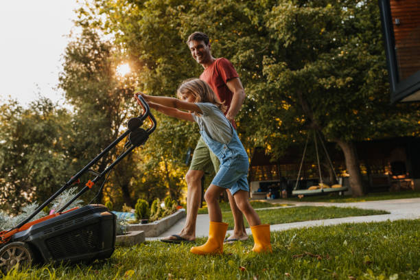 He always help his father in home jobs Father and his little son mowing the lawn together at home fathers day stock pictures, royalty-free photos & images
