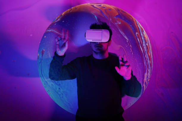He is discovering metaverse by using VR glasses under neon lights stock photo
