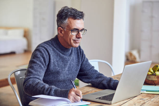 He works hard, from home or the office Shot of a handsome and mature businessman working from home mature men stock pictures, royalty-free photos & images