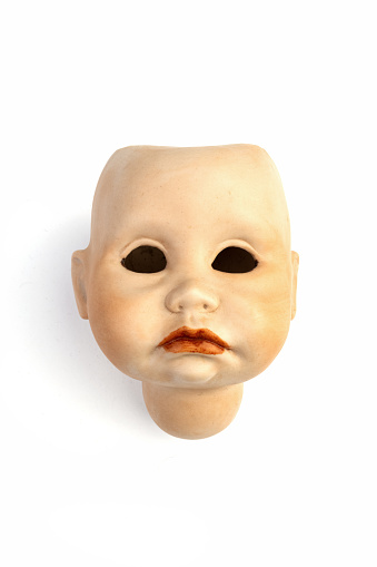 Head without hair and eyes of an old doll - isolated against a white background