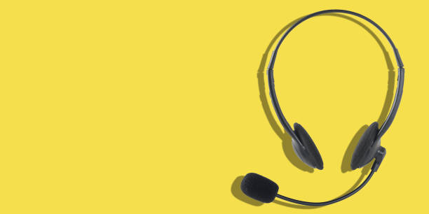 Headphones with a microphone on a yellow background. Panoramic image with place for your text. stock photo