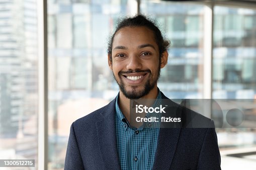 istock Headshot portrait of smiling ethnic businessman in office 1300512215