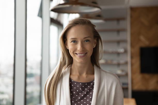 Headshot portrait of smiling female employee posing in office stock photo