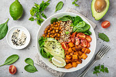 istock healhty vegan lunch bowl. Avocado, quinoa, sweet potato, tomato, spinach and chickpeas vegetables salad 893716434