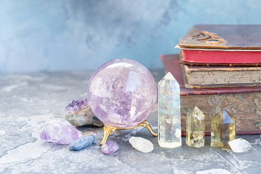 Gemstones set for relax and meditation. Magic ball and semipresious minerals for Reiki life balance with books in background, healing Crystal Ritual, Witchcraft, spiritual esoteric practice.