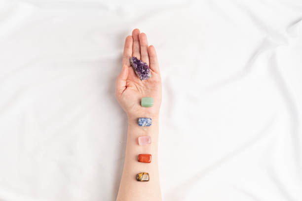 Healing reiki chakra crystals on woman's hands. Gemstones for wellbeing, meditation, relaxation stock photo