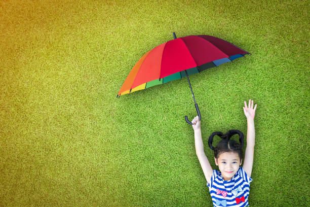 Health care assurance, family and children life insurance medical healthcare business concept with happy asian girl kid holding umbrella uv protection safety from sunlight ray on sunny day Health care assurance, family and children life insurance medical healthcare business concept with happy asian girl kid holding umbrella uv protection safety from sunlight ray on sunny day environmental consciousness stock pictures, royalty-free photos & images