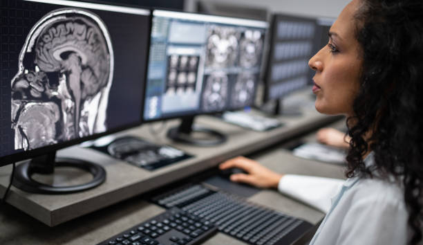 Health Care Female Worker In Hospital With Computer And MRI stock photo