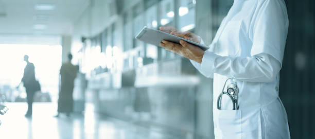 gesundheitswesen und medizin. medizin und technik. arzt arbeitet an digitalem tablet auf krankenhaushintergrund - krankenhaus stock-fotos und bilder