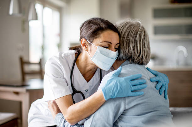operatore sanitario a casa visita - abbracciare una persona foto e immagini stock