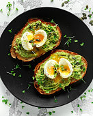 Healthy avocado and egg toasts with pumpkin and sesame seeds, sprinkled with cress salad.