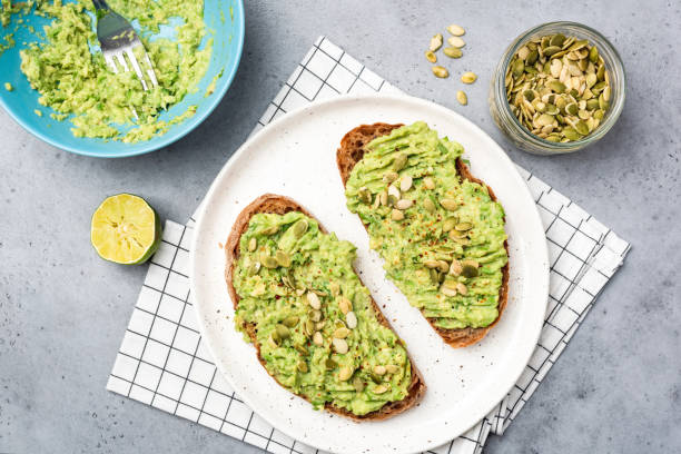 Healthy Avocado Toast With Pumpkin Seeds Healthy Avocado Toast With Pumpkin Seeds. Table Top View. Vegan Vegetarian Diet Food toasted bread stock pictures, royalty-free photos & images