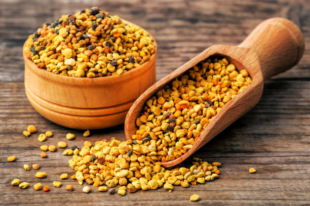 healthy bee pollen on wooden background stock photo