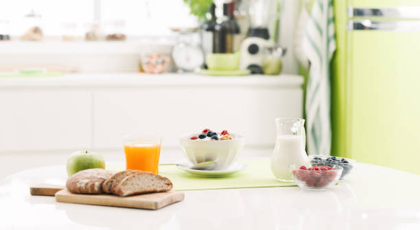 Healthy breakfast at home Delicious healthy breakfast at home with cereals, milk and fresh fruit; kitchen interior on the background breakfast stock pictures, royalty-free photos & images