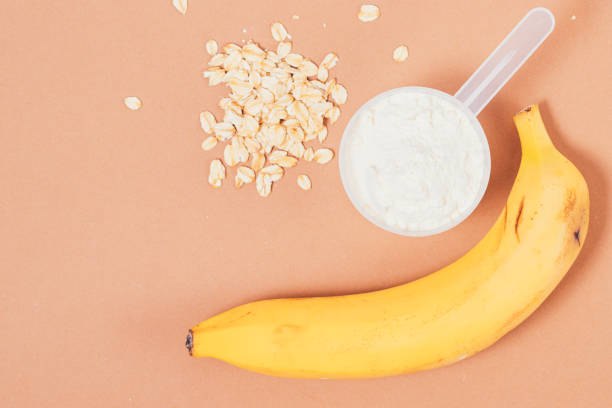 Healthy breakfast protein powder next to fresh banana stock photo