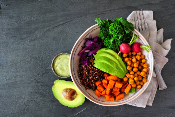 Healthy Buddha bowl with rapini, quinoa, sweet potato, chickpeas and avocado, top view scene over dark slate Healthy Buddha bowl with rapini, quinoa, sweet potato, chickpeas and avocado. Top view scene over a dark slate background. broccoli rabe stock pictures, royalty-free photos & images
