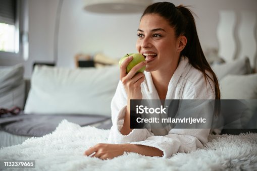 istock Healthy Food, Eating, Lifestyle, Diet Concept. A Woman with apple on bed the bed 1132379665