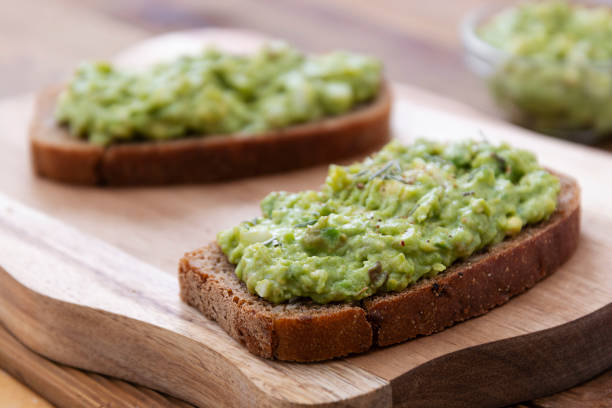 Healthy food. Rye bread with guakomole, avocado pasta on wooden cutting board. Avocado toast for breakfast. Healthy food. Rye bread with guakomole, avocado pasta on wooden cutting board. Avocado toast for breakfast isolated. toasted bread stock pictures, royalty-free photos & images