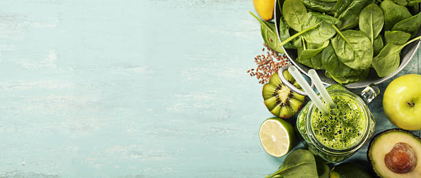 Healthy green smoothie and ingredients on blue background stock photo