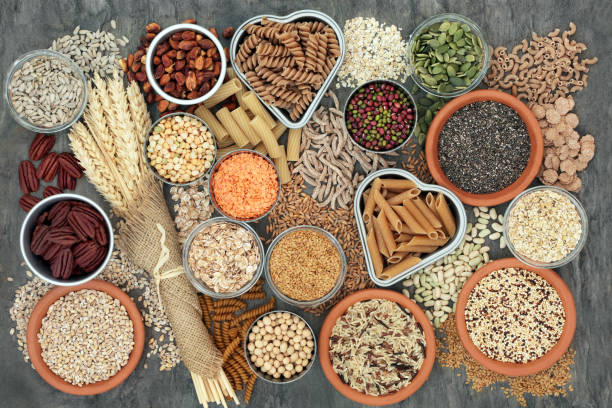 Healthy High Fibre Food Healthy high fibre dietary food concept with whole wheat pasta, legumes, nuts, seeds, cereals, grains and wheat sheaths. High in omega 3, antioxidants, vitamins. On marble background top view. wholegrain stock pictures, royalty-free photos & images