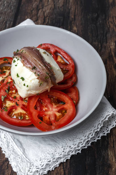 Healthy Homemade Tomato Salad with Mozzarella, Anchovies and Oregano stock photo